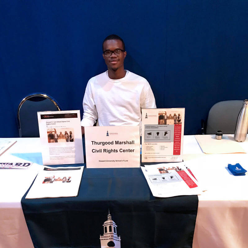 Student sitting at a table promoting the Thurgood Marshall Center at the main Howard University campus